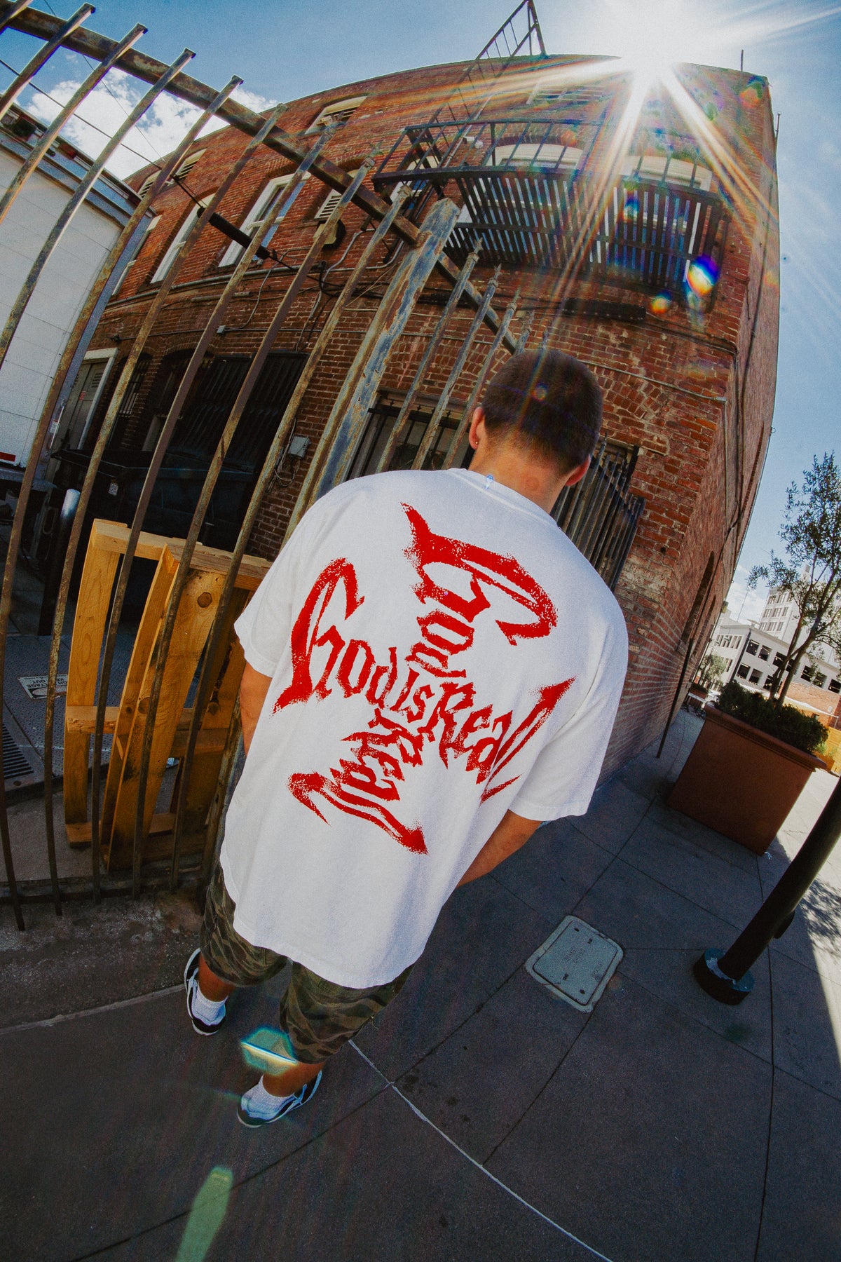 Back view of model in off-white God Is Real tee with red cross graphic