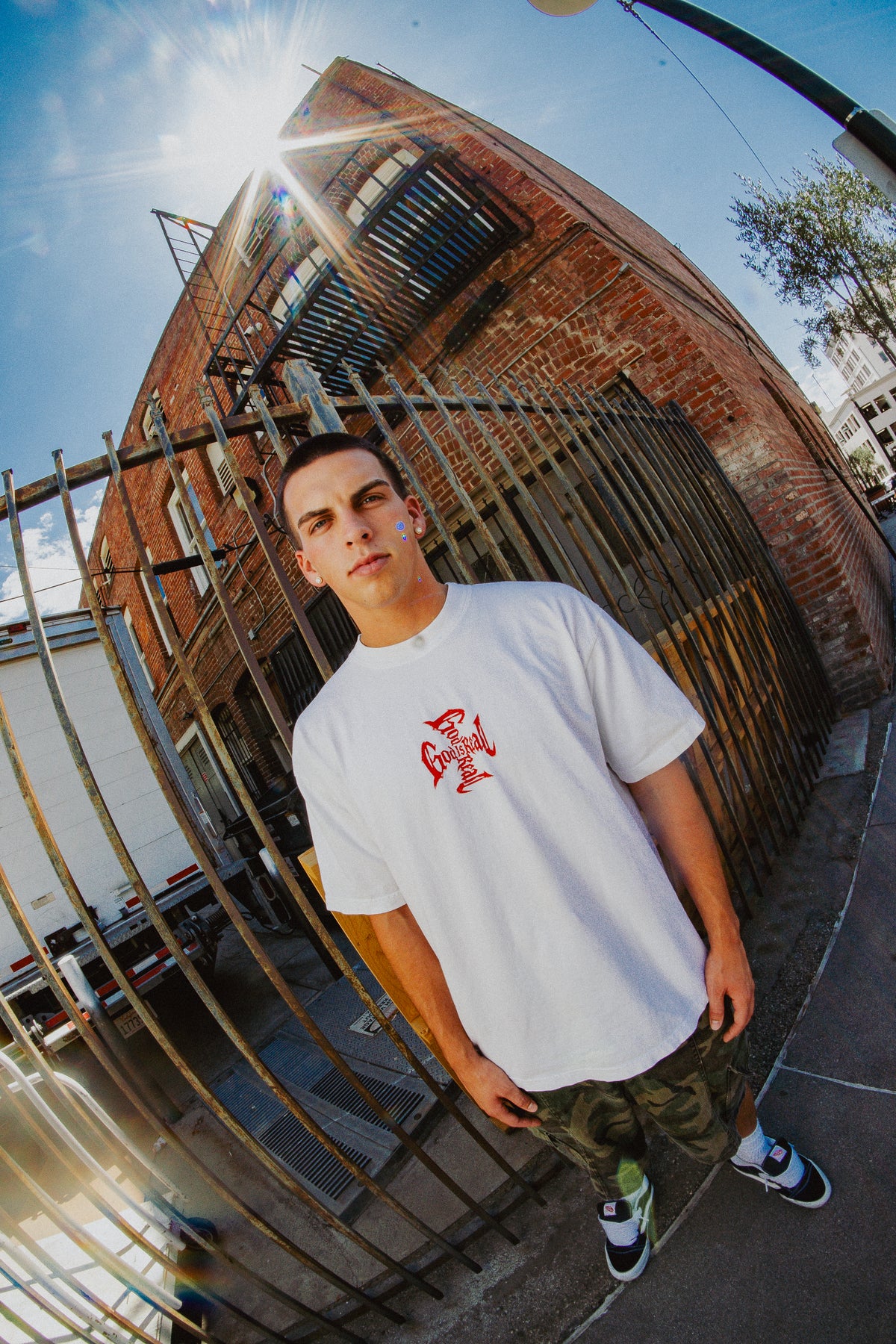 Fisheye street photo of model wearing off-white God Is Real Cross Text Tee